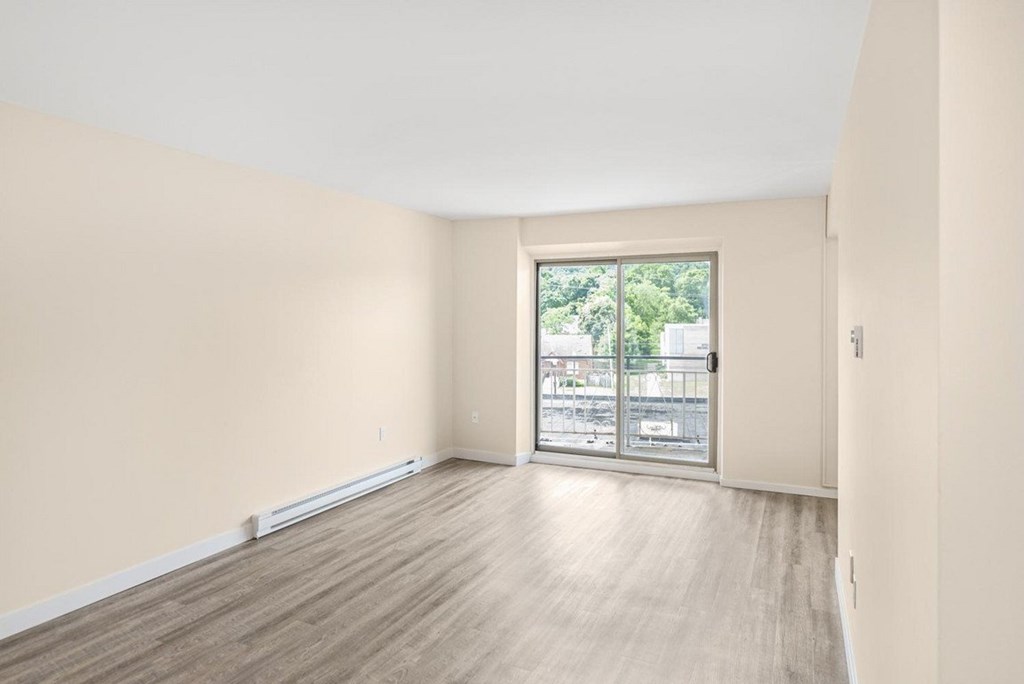 A room with a sliding glass door leading to a balcony.