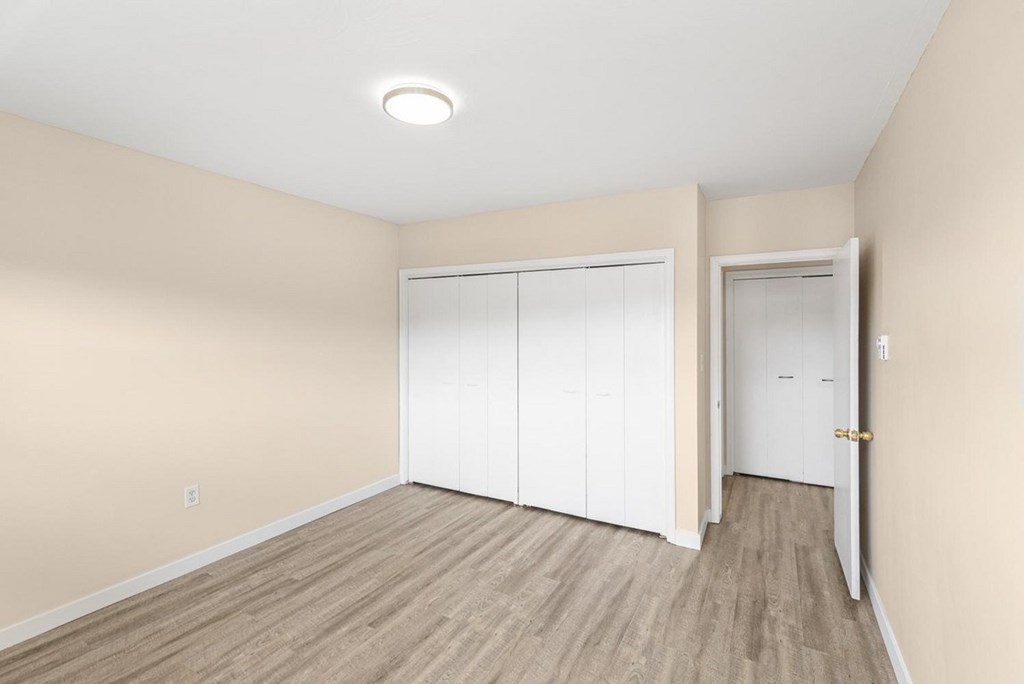 A room with a white closet and a white door.