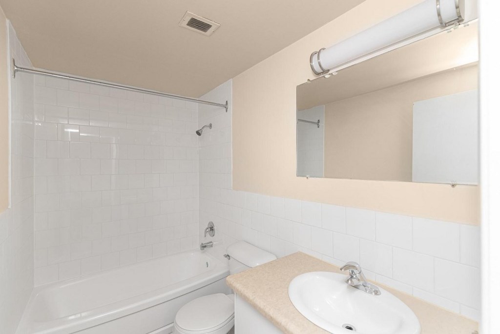 A white bathroom with a toilet, sink, and bathtub.