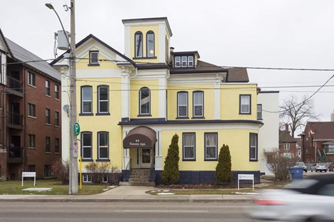 A yellow building with a black roof and a sign that says "The Apk" on it.
