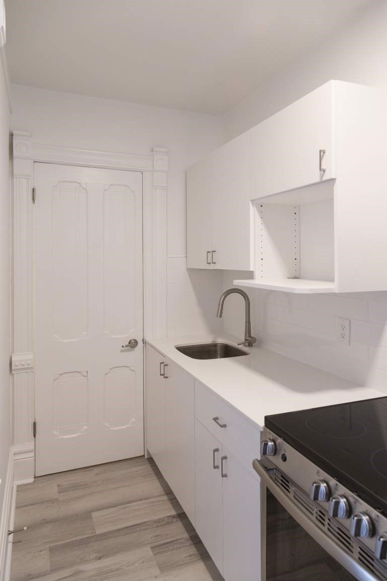 A kitchen with white cabinets and a black stove top.