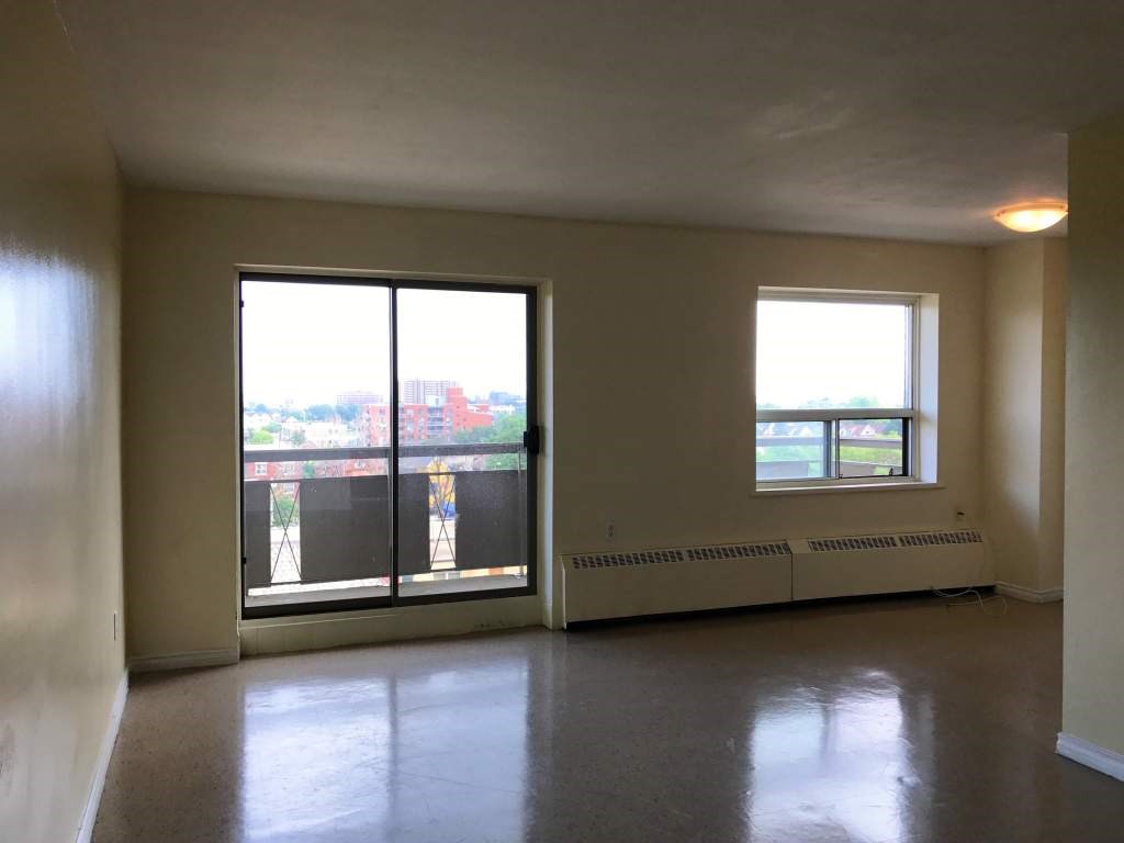 A room with a large window and a balcony.
