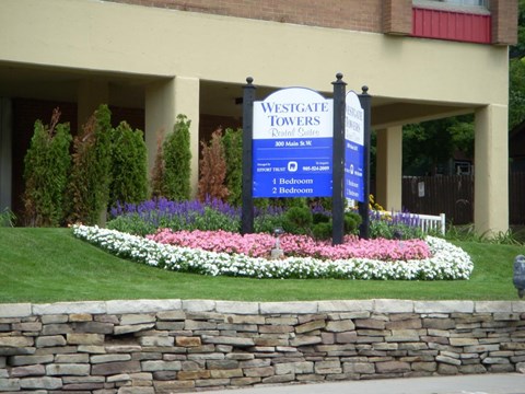 A sign for Westgate Towers is displayed in front of a building.