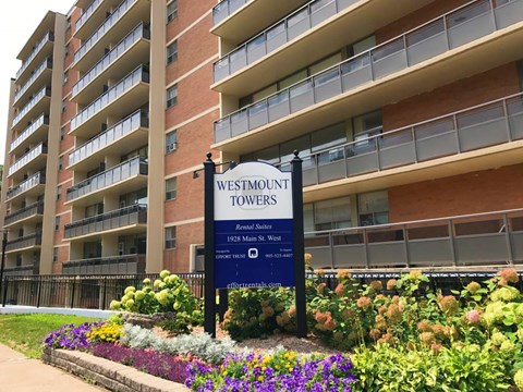 A sign for Westmount Towers stands in front of a building.