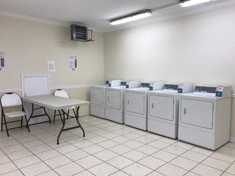 A room with white cabinets and a table with chairs.