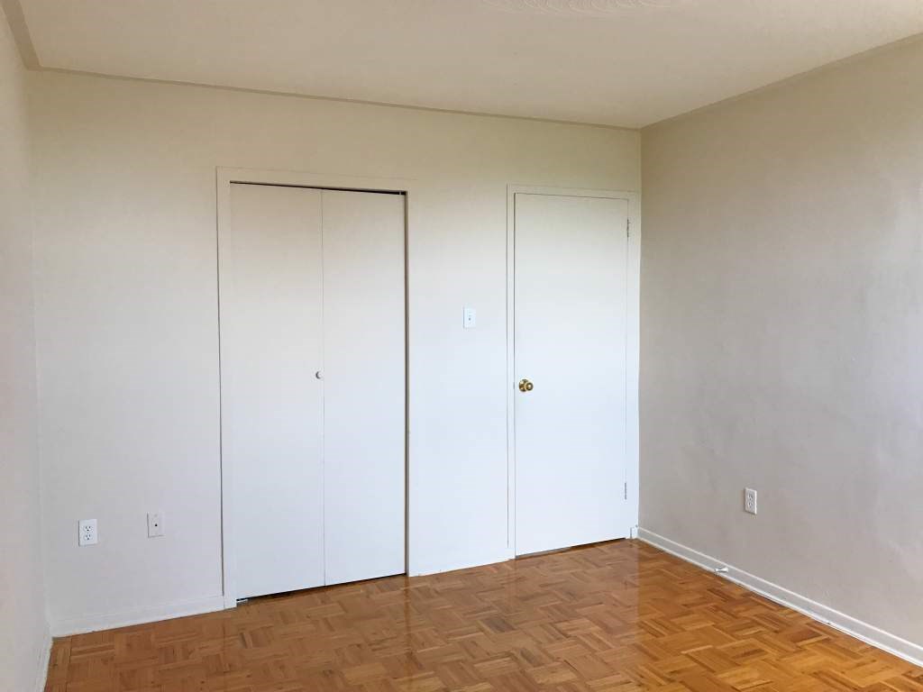 A room with two white doors and wooden flooring.