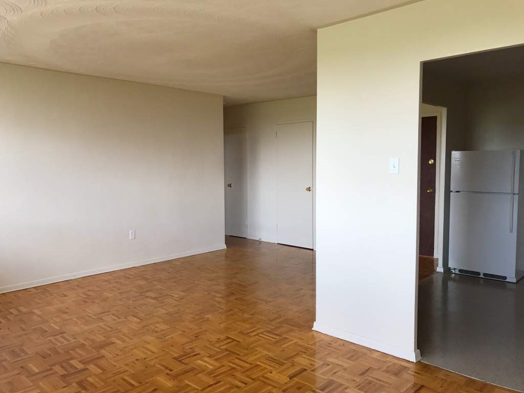 A room with wooden flooring and white walls.