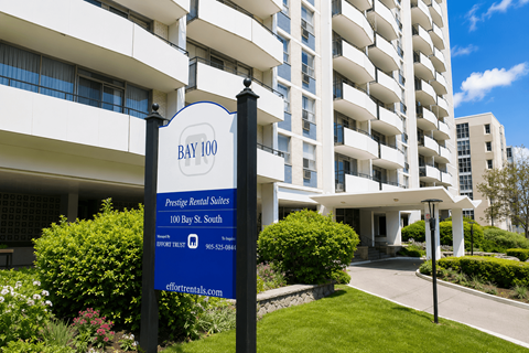 A sign for Bay 100 Prestige Retiree Sales stands in front of a building.