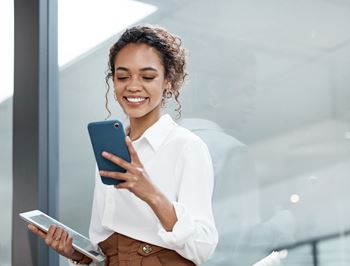 A woman is holding a tablet and a smartphone.at The Maverick, Kitchener, N2H 0E3