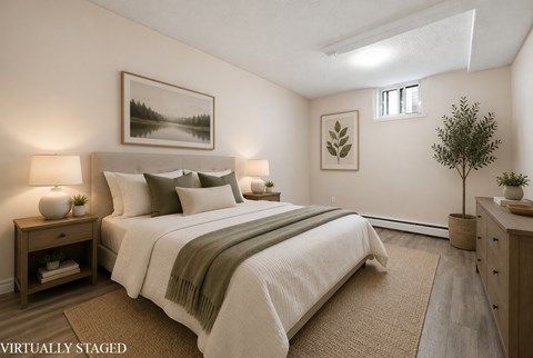 A bedroom with a large bed and a painting on the wall.