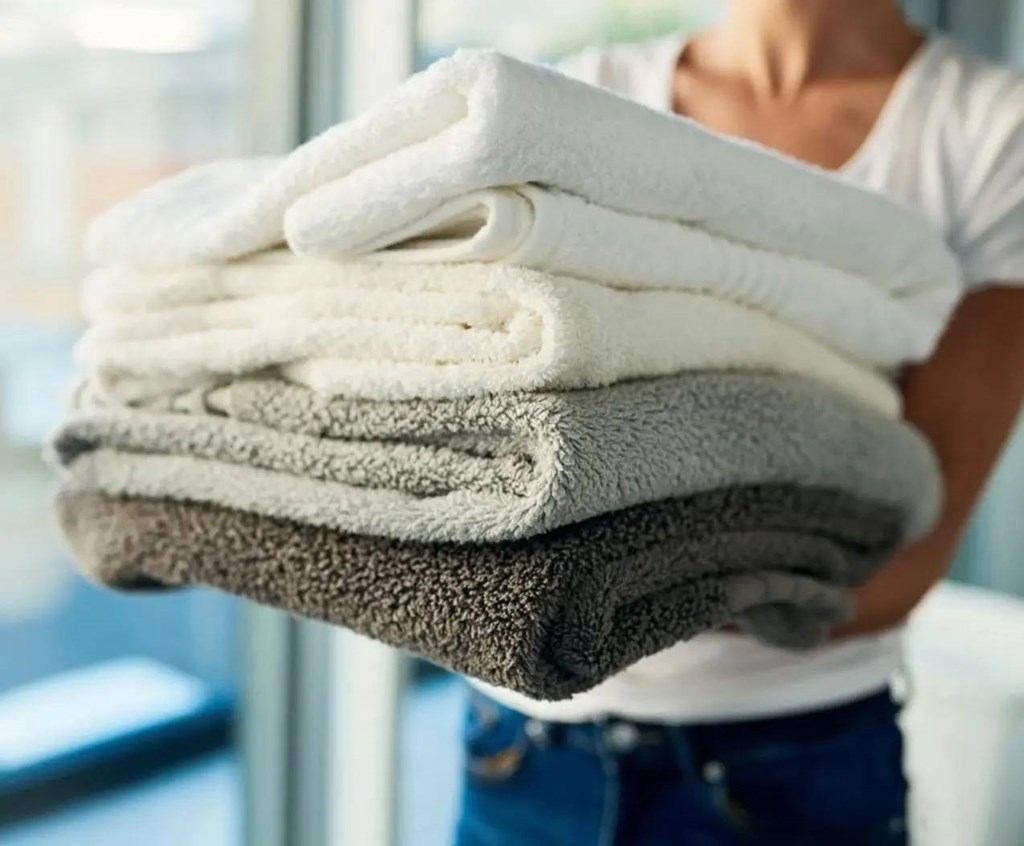 A person holding a stack of towels.at Sylk Towers, Kitchener, ON