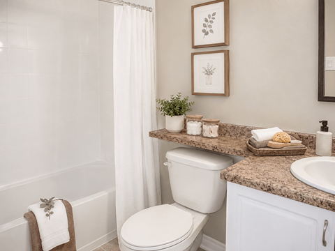 A white toilet sits in a bathroom next to a sink.