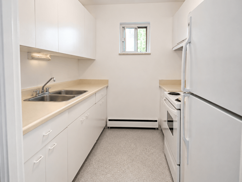 A small, clean kitchen with white appliances and cabinets.