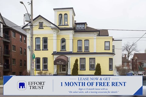A large yellow building with a sign in front that says "Lease Now & Get 1 Month of Free Rent".