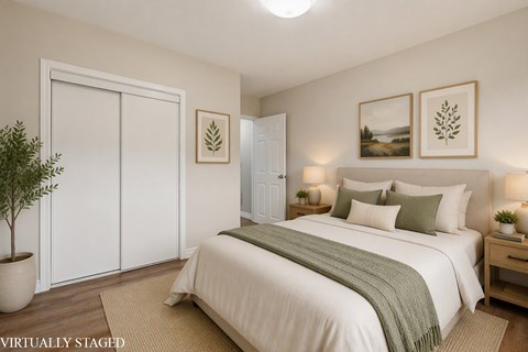 A bedroom with a bed, nightstands, and pictures on the wall.