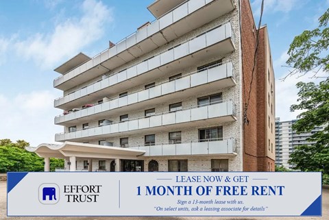 A tall apartment building with a sign offering a free month of rent.