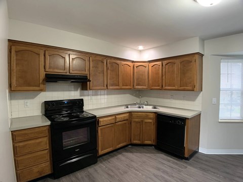 A kitchen with wooden cabinets and black appliances.