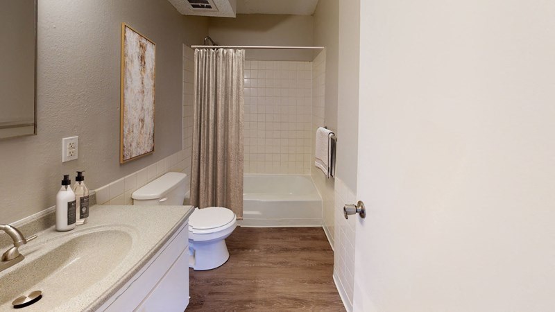 A bathroom with a toilet, sink, and shower.
