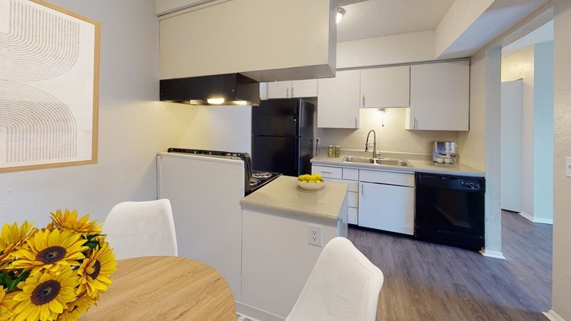 A kitchen with a refrigerator, stove, dishwasher, and dining area.