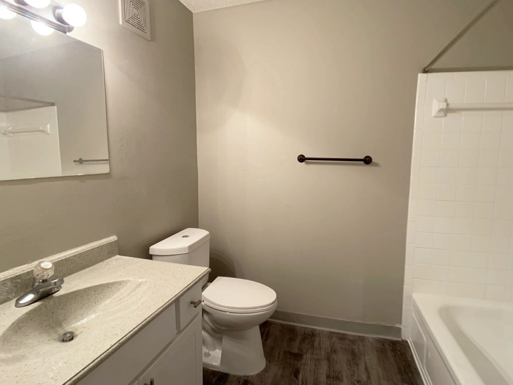 A bathroom with a toilet, sink, and bathtub.