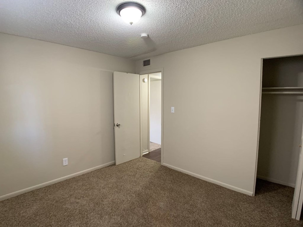 A room with a carpeted floor and a ceiling light.