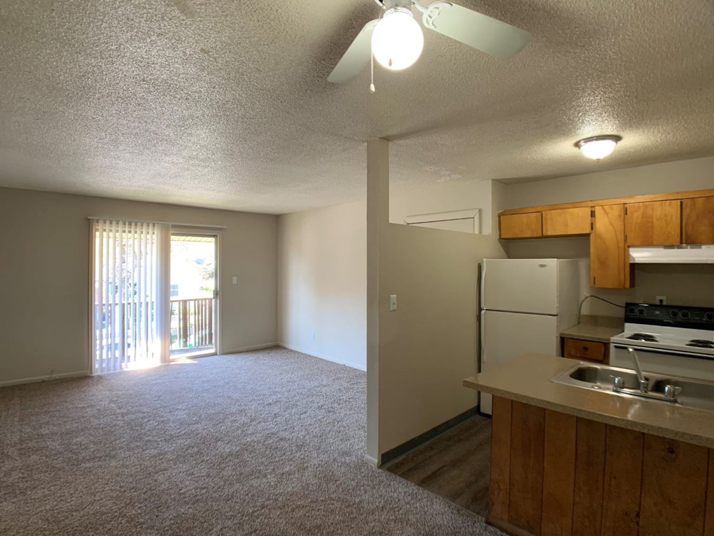 A kitchen area with a refrigerator, sink, and stove.
