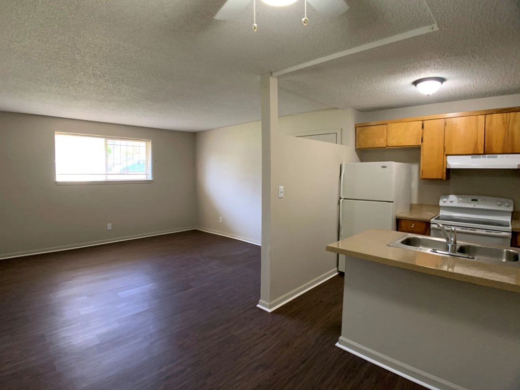 A kitchen area with a refrigerator, sink, and cabinets.