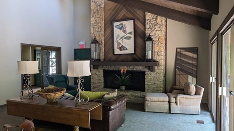 A living room with a fireplace and a painting above it.