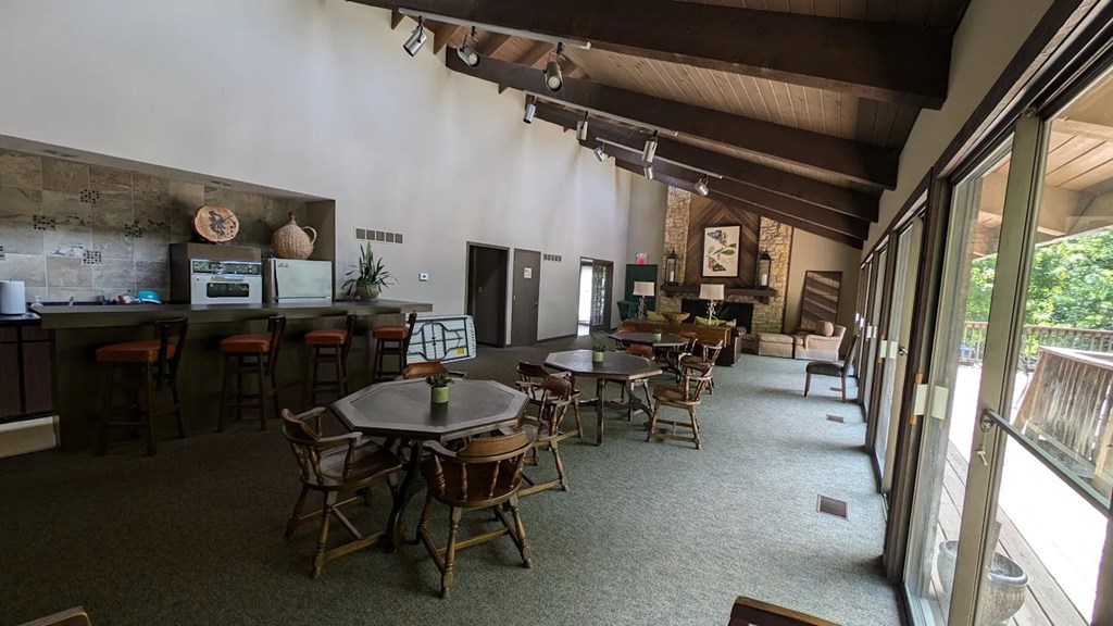 A dining room with multiple tables and chairs and a bar area.