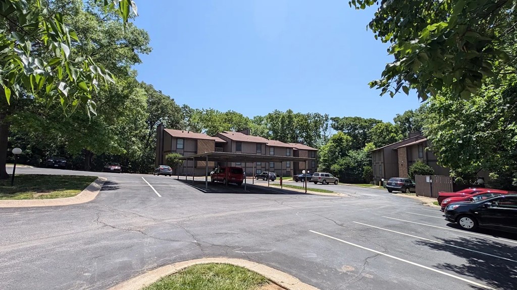 A parking lot with cars and buildings in the background.