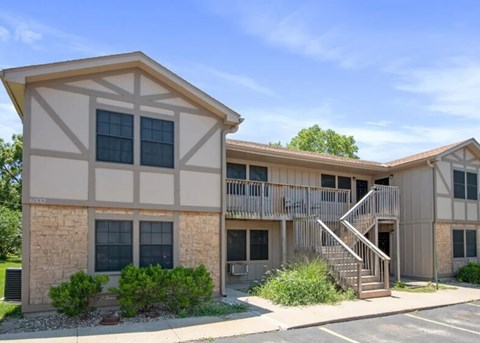 A building with a stone facade and a balcony with a metal railing.