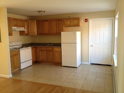 A kitchen with wooden cabinets and white appliances.