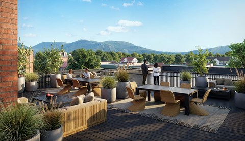 A patio with a table and chairs overlooking a mountainous landscape.