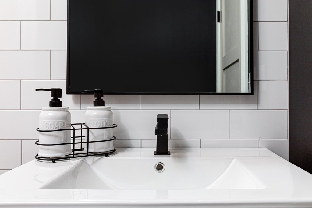 A white sink with two soap dispensers on top of it.