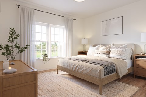 A bedroom with a large bed and a nightstand with a vase on it.