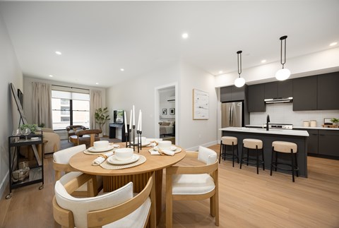A modern dining room with a wooden table and chairs.