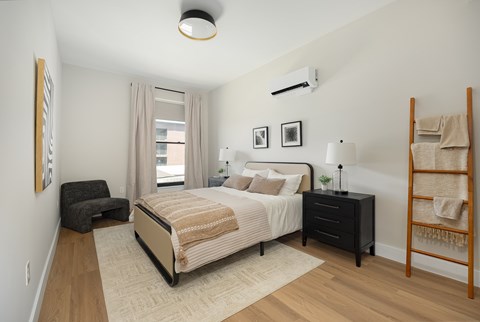 A bedroom with a large bed and a chair.