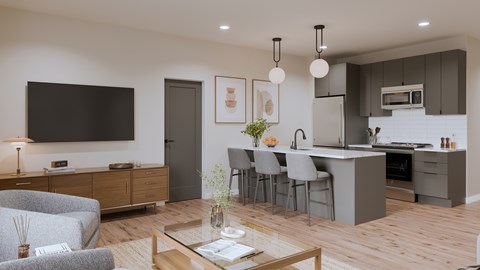A modern living room with a grey couch, a wooden coffee table, and a kitchen area in the background.