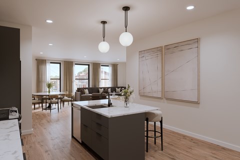 A modern kitchen with a large island and pendant lights.