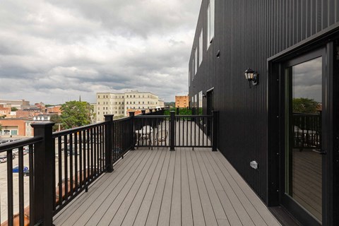A balcony with a black railing and a black door.