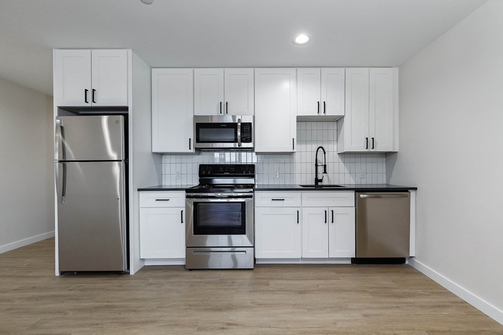 A kitchen with white cabinets and stainless steel appliances.