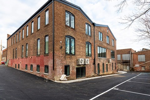 A large brick building with a parking lot in front.