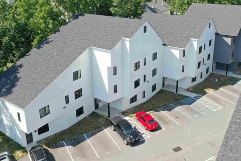 A white building with a parking lot in front.