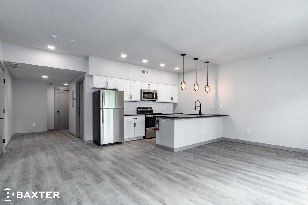 A modern kitchen with stainless steel appliances and a bar area.