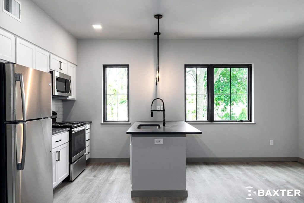 A modern kitchen with a large island and stainless steel appliances.