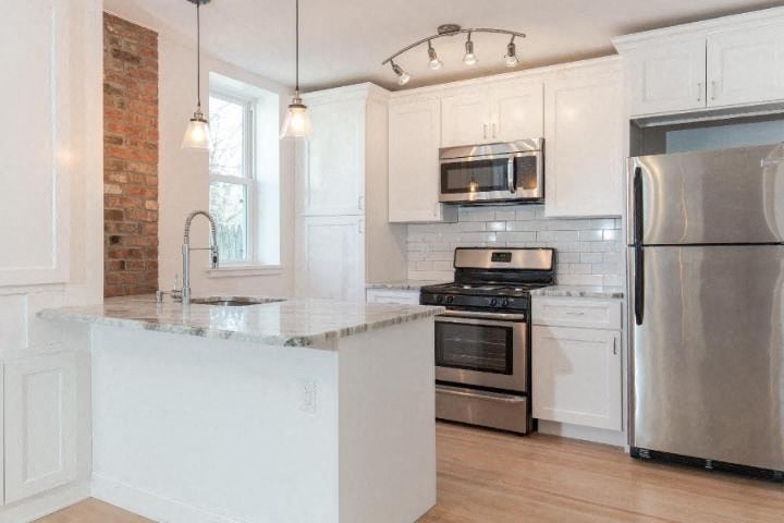 A kitchen with a white island and stainless steel appliances.