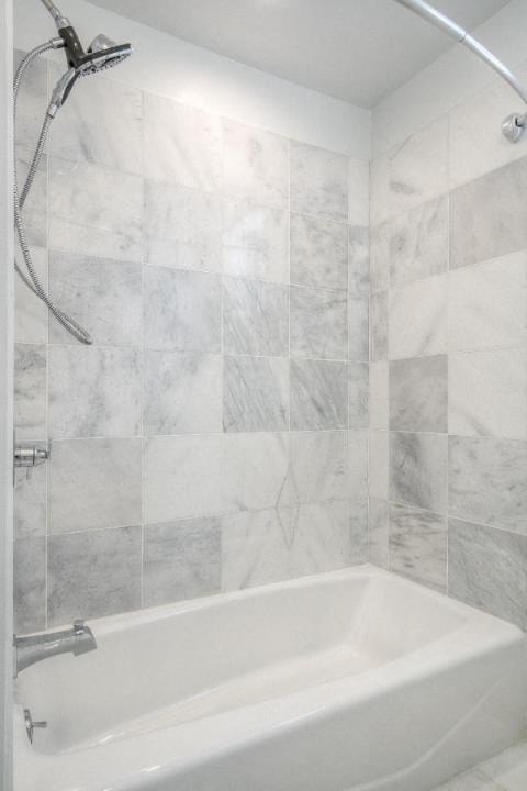 A white bathtub with a silver faucet and a silver shower head.