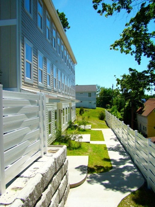 A white building with a white fence in front of it.
