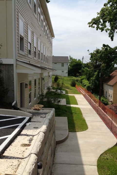 A long white building with a green lawn in front.