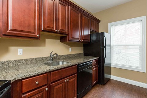 A kitchen with brown cabinets and black appliances.